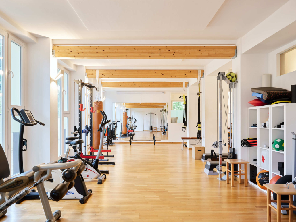 Banner für Physiotherapie-Job in Berlin-Zehlendorf-Schlachtensee. Heller Trainingsraum mit Kraft- und Ausdauergeräten in der Praxis Schlachtensee.